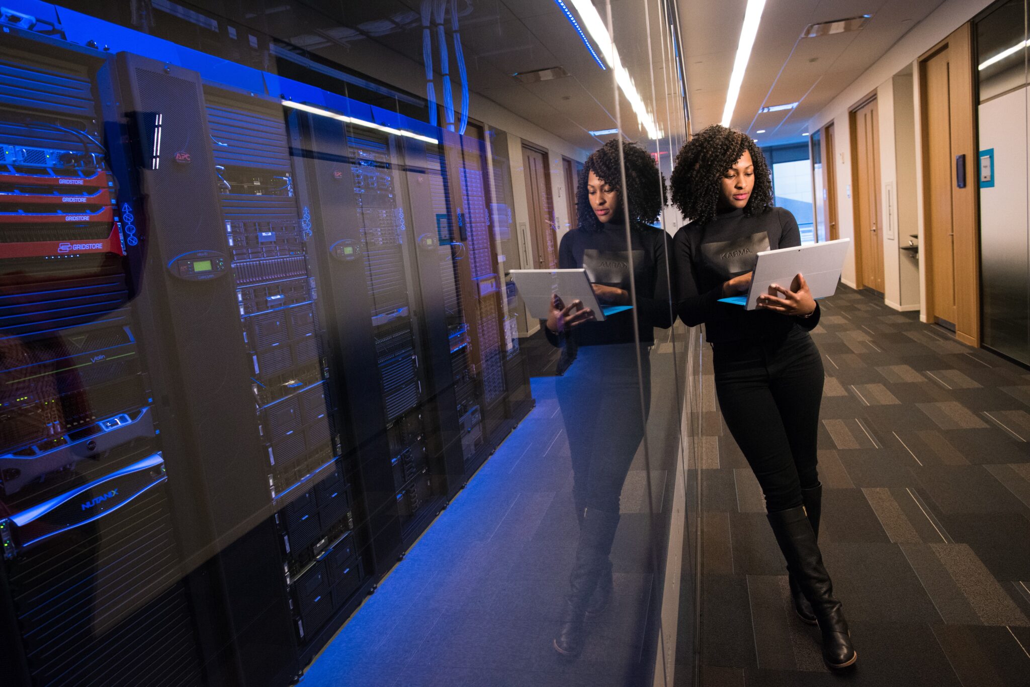African American woman looking at laptop in a data center