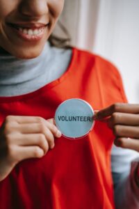 lady in orange top with a volunteer badge